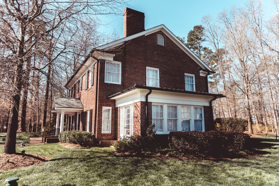 Two-story brick house surrounded by bare trees