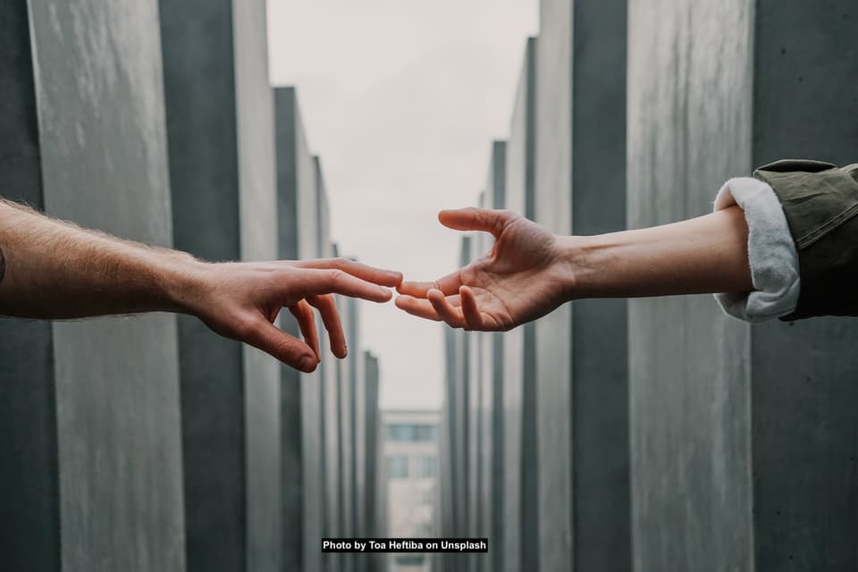 Two hands reaching toward each other