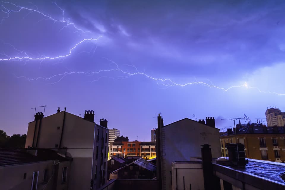 Lightning over a line of trees at night